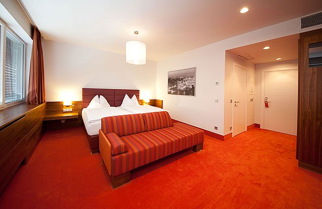 Hotel Ambio Zimmer mit Doppelbett rotem Teppich und einer roten Couch